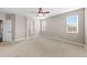 Large bedroom with neutral walls and carpet featuring two bright windows and a ceiling fan at 15715 Carob Cir, Parker, CO 80134