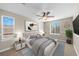 This bedroom is staged with a queen bed, side tables, art, a plant, and a ceiling fan at 15715 Carob Cir, Parker, CO 80134