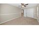 This bedroom has neutral walls, carpeted floors, a ceiling fan, white trim, and a closet at 15715 Carob Cir, Parker, CO 80134