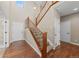 Grand foyer showcasing a hardwood floor, carpeted staircase with wooden handrail and metal spindles, and a high ceiling at 15715 Carob Cir, Parker, CO 80134