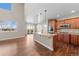 Kitchen with granite island, pendant lighting, stainless appliances, and hardwood floors at 15715 Carob Cir, Parker, CO 80134