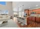 Bright kitchen and living room with hardwood floors, granite counters, island, and modern stainless-steel appliances at 15715 Carob Cir, Parker, CO 80134