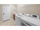 Well-equipped laundry room featuring new white washer and dryer units with countertop and built-in wire rack at 15715 Carob Cir, Parker, CO 80134