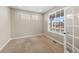 Office with a neutral carpet, white walls, and multiple windows, featuring large blinds and a glass paneled door at 15715 Carob Cir, Parker, CO 80134