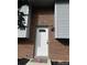Close up of the front door with a new exterior light and well kept brick at 10630 Routt Way, Broomfield, CO 80021