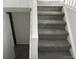 Carpeted staircase leading to the basement with a white banister and open doorway at 10630 Routt Way, Broomfield, CO 80021