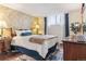 The primary bedroom includes decorative wall, hardwood floors, and a large window with curtains at 2375 S Linden Ct # 118, Denver, CO 80222