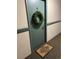 Charming front door with a welcome mat and green wreath, creating an inviting entrance at 2375 S Linden Ct # 118, Denver, CO 80222