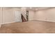 A large finished basement with tan carpet and a stairwell to the upper floor at 13015 Tamarac Pl, Thornton, CO 80602