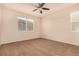 A well-lit bedroom featuring neutral walls, brown carpet, and a ceiling fan at 13015 Tamarac Pl, Thornton, CO 80602