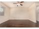 Minimalist bedroom with hardwood floors, a ceiling fan, and a large window for natural light at 13015 Tamarac Pl, Thornton, CO 80602