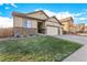 Charming home with a three-car garage, stone accents, and a lush green lawn on a sunny day at 13015 Tamarac Pl, Thornton, CO 80602