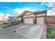 Beautiful home with a three-car garage, stone accents, and a well-maintained yard on a sunny day at 13015 Tamarac Pl, Thornton, CO 80602