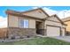 Attractive single-story home featuring a three-car garage, stone accents, and a well-maintained lawn at 13015 Tamarac Pl, Thornton, CO 80602