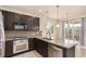 Modern kitchen features stainless steel appliances, stone countertop island, and ample cabinetry at 13015 Tamarac Pl, Thornton, CO 80602