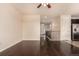 Open-concept living space with dark hardwood floors connecting to a staircase and kitchen at 13015 Tamarac Pl, Thornton, CO 80602
