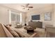 Cozy living room with neutral decor, a comfortable sofa, and a large window for natural light at 13015 Tamarac Pl, Thornton, CO 80602