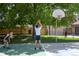 People playing basketball on an outdoor court with mature trees and a residential home at 1652 N Lafayette St # 6, Denver, CO 80218