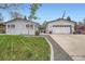 Charming home featuring a brick facade, well-manicured lawn, and an attached two-car garage at 1025 Zang St, Golden, CO 80401