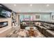 Bright living room featuring a large leather sectional, fireplace, and sliding glass doors to the backyard at 1025 Zang St, Golden, CO 80401