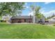 Expansive backyard features a large patio, manicured lawn, and mature trees, ideal for outdoor entertaining and recreation at 7440 Quail St, Arvada, CO 80005