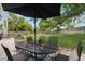Lush backyard featuring a dining table, and mature trees, ideal for outdoor entertaining and relaxation at 7440 Quail St, Arvada, CO 80005