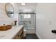 Bright bathroom featuring a modern vanity, decorative mirror, shiplap wall accent, and a glass shower at 7440 Quail St, Arvada, CO 80005