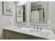 Bathroom with a double sink vanity, framed mirrors, and a sliding barn door at 7440 Quail St, Arvada, CO 80005
