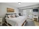 Bright bedroom with a queen bed, a window, and a door leading to a deck at 7440 Quail St, Arvada, CO 80005