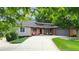 Front exterior of home with brick and grey siding, professional landscaping, and a wide driveway at 7440 Quail St, Arvada, CO 80005