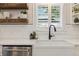 Stylish white farmhouse sink and backsplash with floating shelves at 7440 Quail St, Arvada, CO 80005