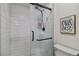 Shower with white tiled walls, glass door, and black hardware at 7440 Quail St, Arvada, CO 80005