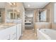 Bright bathroom featuring tile floor, double vanity and soaking tub with tiled surround at 4221 Pioneer Pl, Brighton, CO 80601