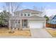 Charming two-story home featuring a welcoming front porch, stone accents, and a well-maintained lawn at 4221 Pioneer Pl, Brighton, CO 80601