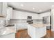 Spacious kitchen with white cabinets, granite counters, island, and stainless steel appliances at 4221 Pioneer Pl, Brighton, CO 80601