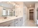 Stylish primary bathroom with double vanity, tiled shower, and bright lighting at 9771 Rosalee Peak St, Littleton, CO 80125
