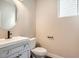 Clean half bath with modern vanity, faucet, toilet, and gray cabinets at 9771 Rosalee Peak St, Littleton, CO 80125
