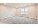 Neutral bedroom with carpet, white trim, and a window for natural light at 9771 Rosalee Peak St, Littleton, CO 80125