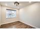 Neutral bedroom with hardwood floors, white trim, and a window for natural light at 9771 Rosalee Peak St, Littleton, CO 80125