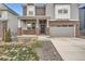 Attractive two-story home with brick accents, front porch and two-car garage at 9771 Rosalee Peak St, Littleton, CO 80125
