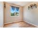 Bright, sunlit bedroom with hardwood floors, a large window offering a view of the neighborhood, and minimal decor at 2333 Paint Pony Cir, Castle Rock, CO 80108