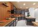 Well lit kitchen featuring wood accents, black cabinets, stainless steel appliances, and light tile floors at 2333 Paint Pony Cir, Castle Rock, CO 80108