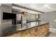 Basement kitchenette featuring stone bar, stainless appliances, and dark countertop, perfect for entertaining guests at 2333 Paint Pony Cir, Castle Rock, CO 80108