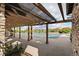Covered outdoor pool with a stone brick wall and wooden beams for shade and protection at 2333 Paint Pony Cir, Castle Rock, CO 80108