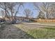 Large backyard with grass, trees, and a patio area perfect for relaxing and entertaining at 3094 S Hobart Way, Denver, CO 80227