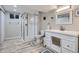 Modern bathroom featuring a glass shower enclosure, white vanity, and stylish gray wood-look flooring at 3094 S Hobart Way, Denver, CO 80227