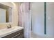 Bathroom with modern vanity, a framed mirror, shower with purple curtains and white tiled walls at 3094 S Hobart Way, Denver, CO 80227