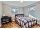 Bedroom features hardwood flooring, two windows offering natural light, and a desk at 3094 S Hobart Way, Denver, CO 80227