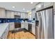 Updated kitchen with stainless steel appliances, gray cabinets, and hardwood flooring at 3094 S Hobart Way, Denver, CO 80227