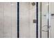 Glass shower featuring white tile with decorative blue border and brushed nickel hardware at 3094 S Hobart Way, Denver, CO 80227